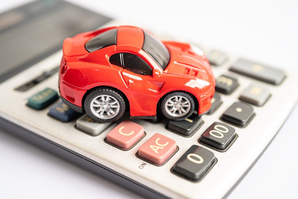 Red toy car on top of Calculator